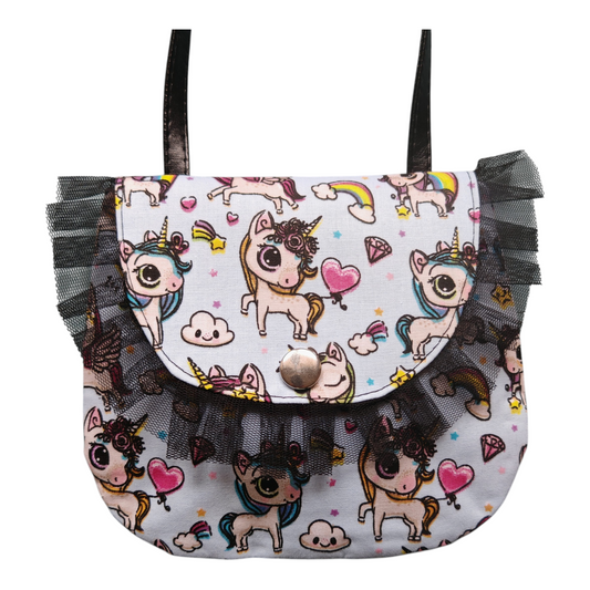 Petit sac bandoulière artisanal Bonnie pour enfant, imprimé licornes et arcs-en-ciel féeriques, détails en tulle noir froncé sur fond blanc.
