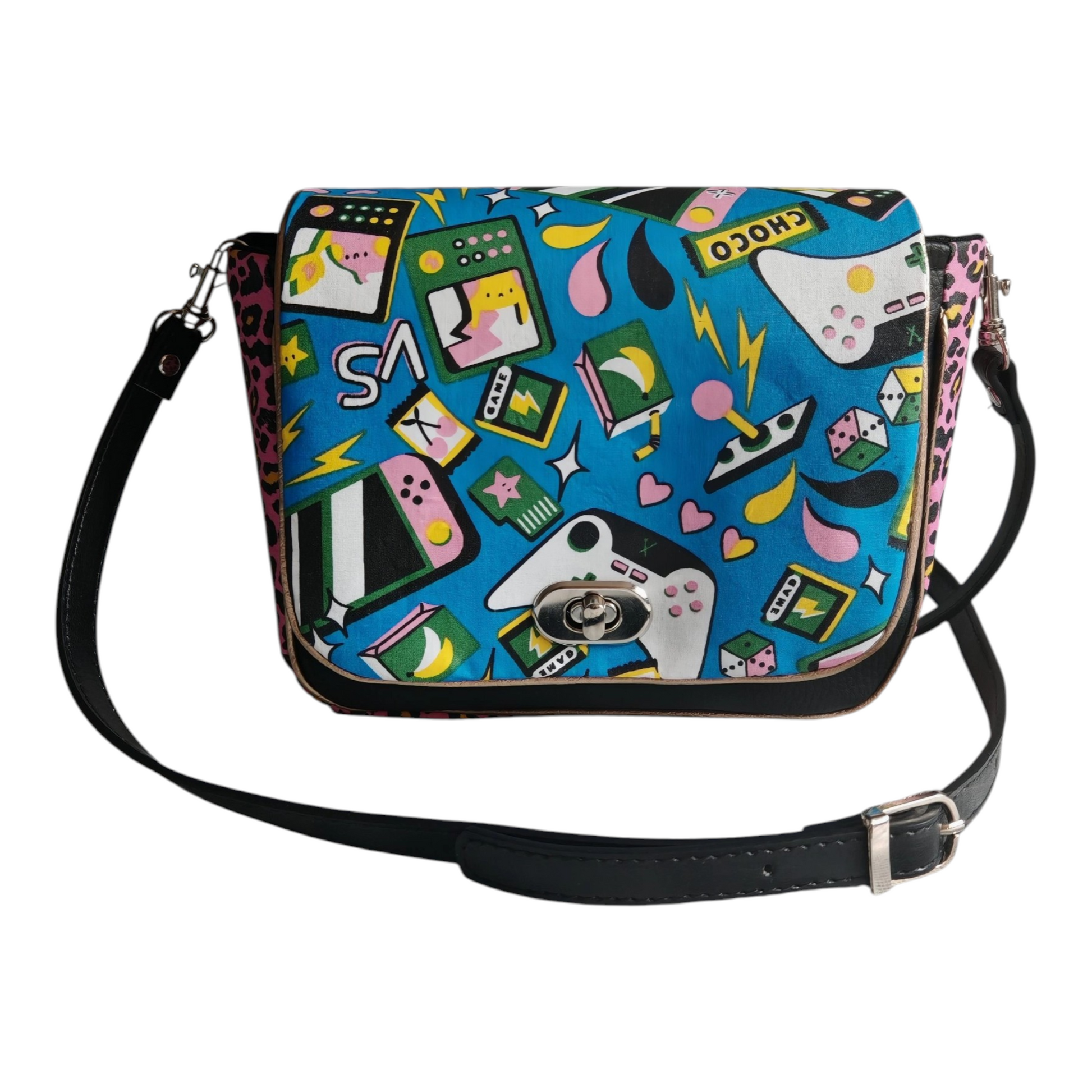 Sac à main bandoulière Les RoQuettes

Modèle Lady geek pour un style très coloré inspiré des années 80, geek style. 

Sac à rabat motif jeux vidéos des année 80 multicolore et de  léopard rose.

Muni d'un fermoir tourniquet argent et anse en simili cuir noir amovible.

Petite poche intérieure pour y glisser ses clés.

Dimensions: 16 x 24 x 7 cm

Longueur de la anse: 110 cm

Matière: coton/viscose et simili cuir / doublure: coton