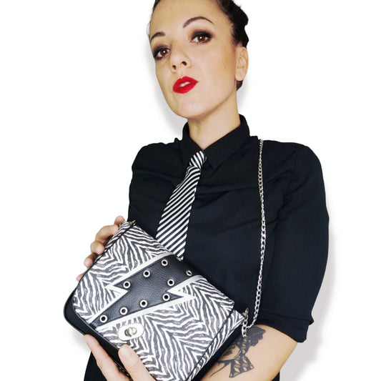Look femme avec sac à rabat zébré Bowie Zebra porté à l'épaule, style rock chic.