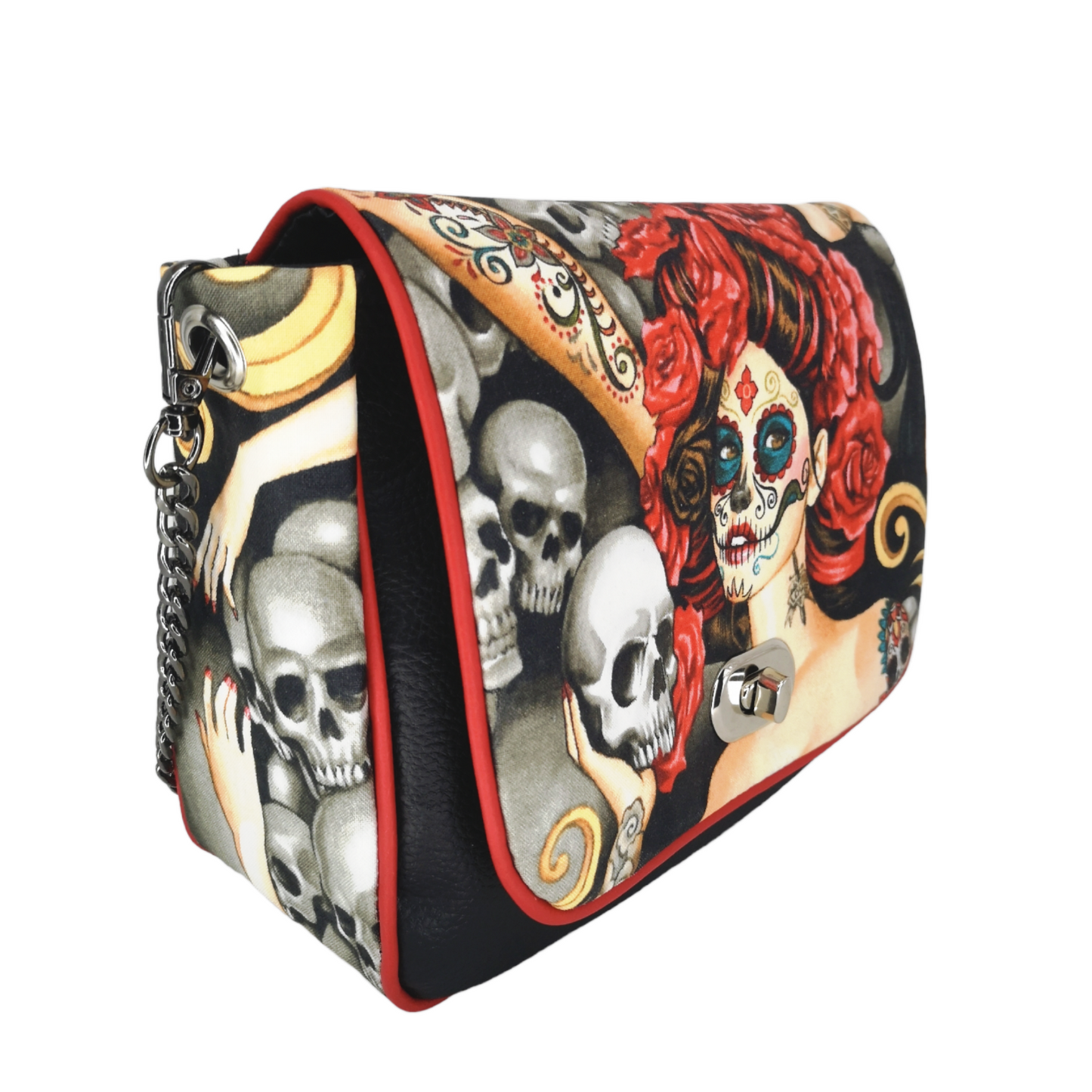 Sac à main à rabat motif têtes de mort mexicaine, calavera et fleurs.  Munit d'un fermoir tourniquet argent et d'une chaîne argent bandouilère amovible.